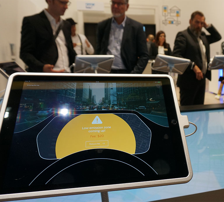 A room with people watching an SAP showcase on Ipads can be seen