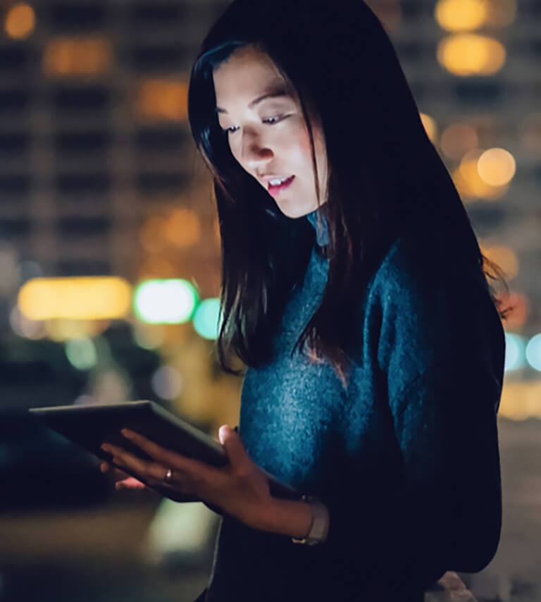 An example of the visual language is a photo of a young lady looking at a tablet in front of a nighttime city backdrop