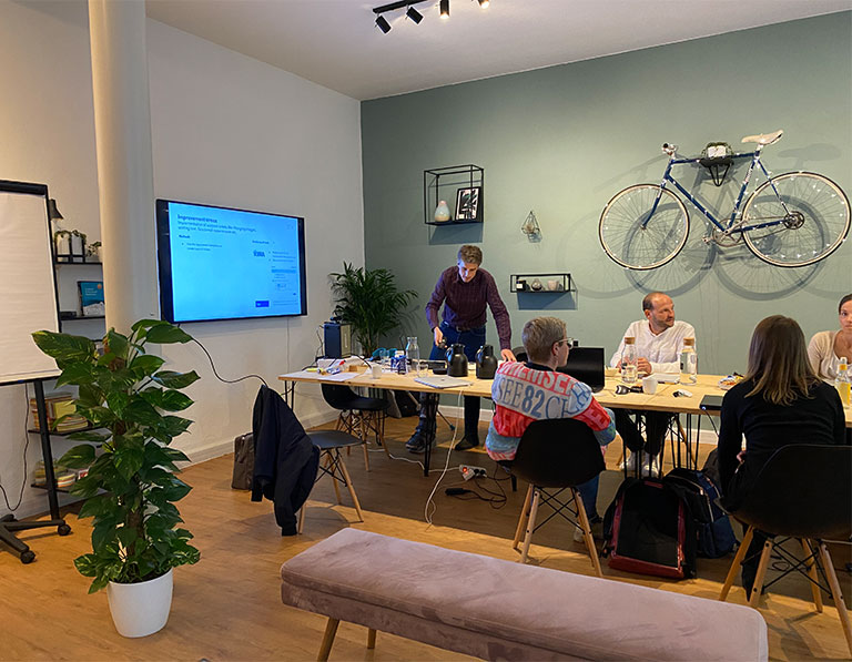 Foto: Consultants in einem Workshop mit Kunden in einem modernen Meetingraum.