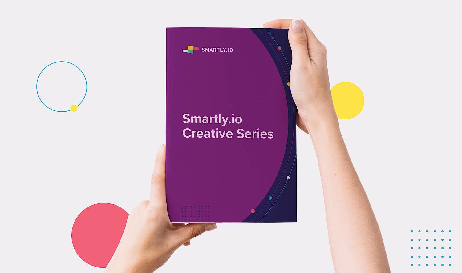 Photo of a closed book from Smartly.io that someone is holding and presenting