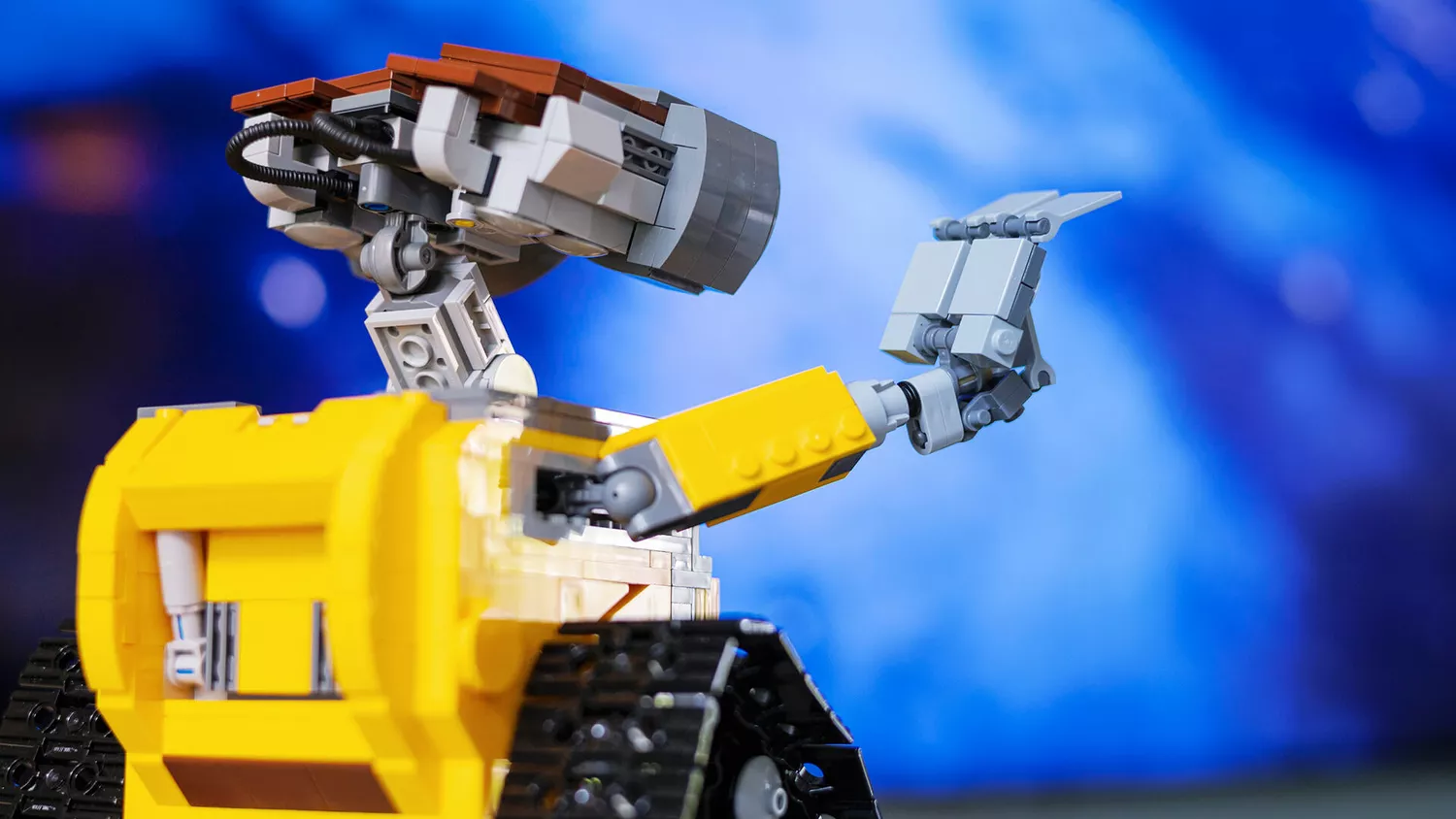Zu sehen ist das Foto eines kleinen Roboters, der seine Hand hebt.